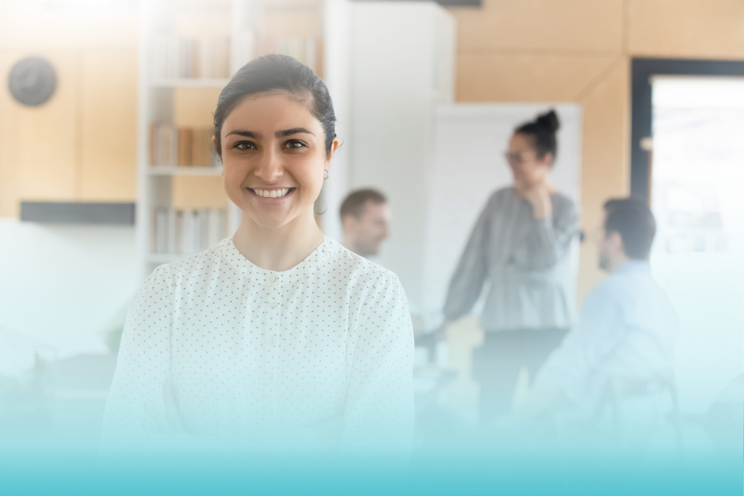 Head shot portrait smiling confident Indian businesswoman with arms crossed standing in modern office with colleagues on background, successful happy employee entrepreneur executive looking at camera