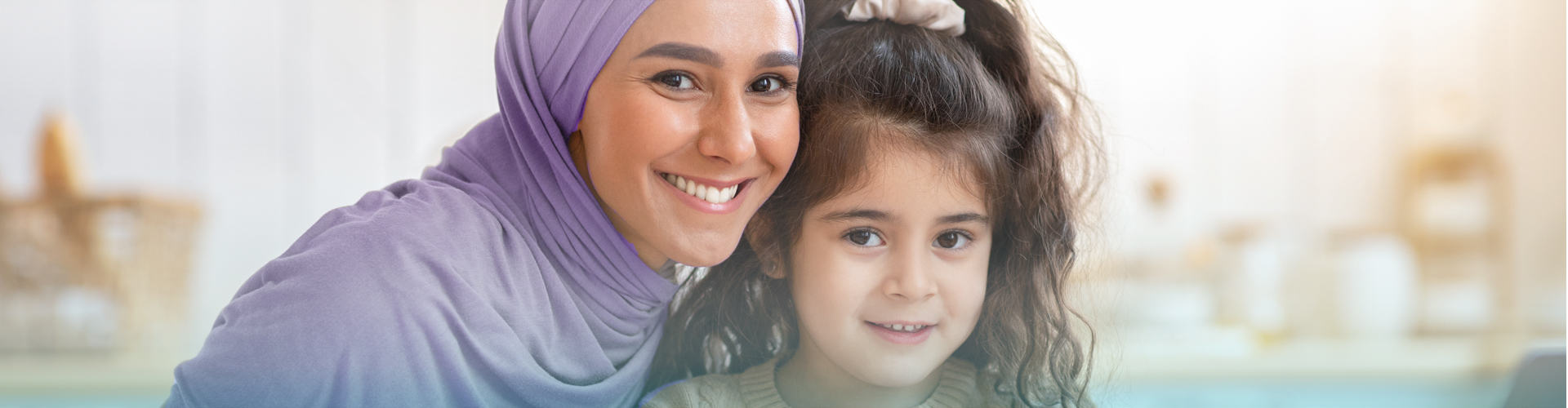 Portrait Of Happy Muslim Mom And Little Daughter Posing In Kitchen Interior While Having Fun Together At Home, Cheerful Family Sitting At Table And Drawing With Colorful Pencils, Smiling At Camera